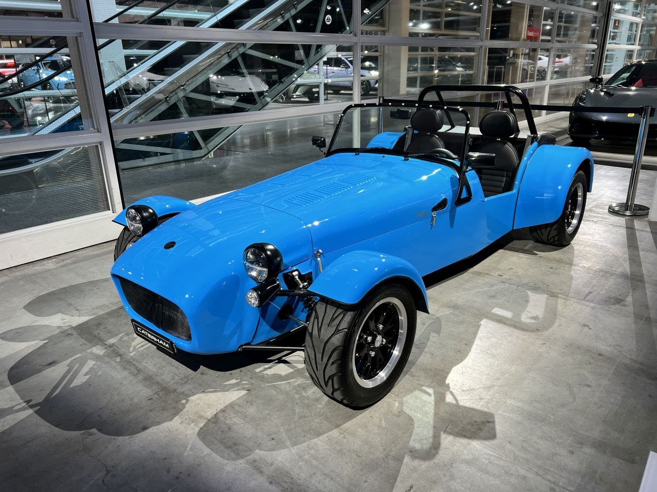 Open-wheel roadster with exposed headlights and black roll bar