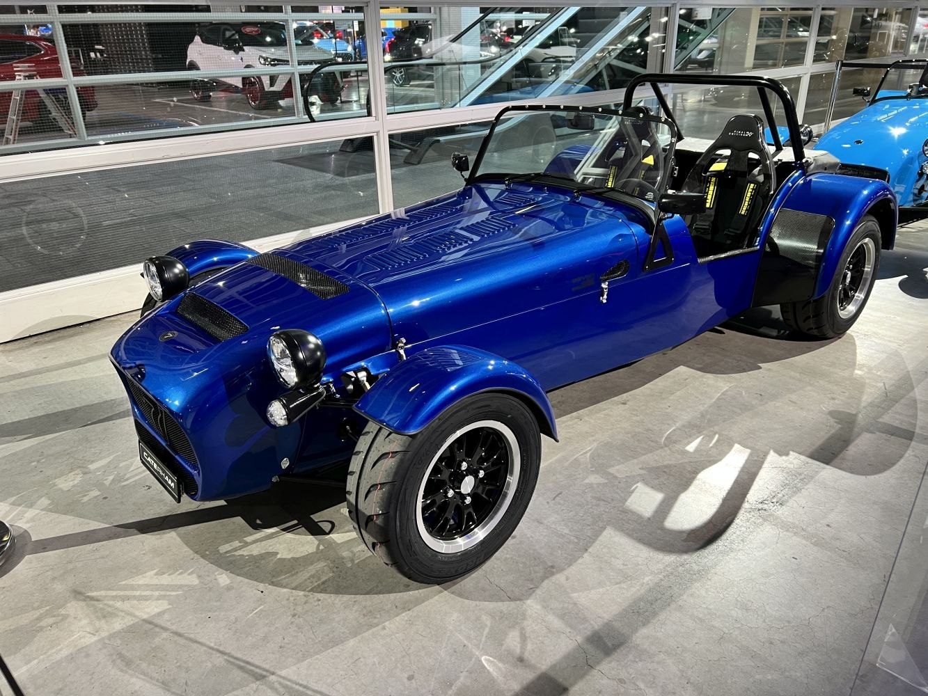 Open-top lightweight sports vehicle with exposed front wheels and racing seats.