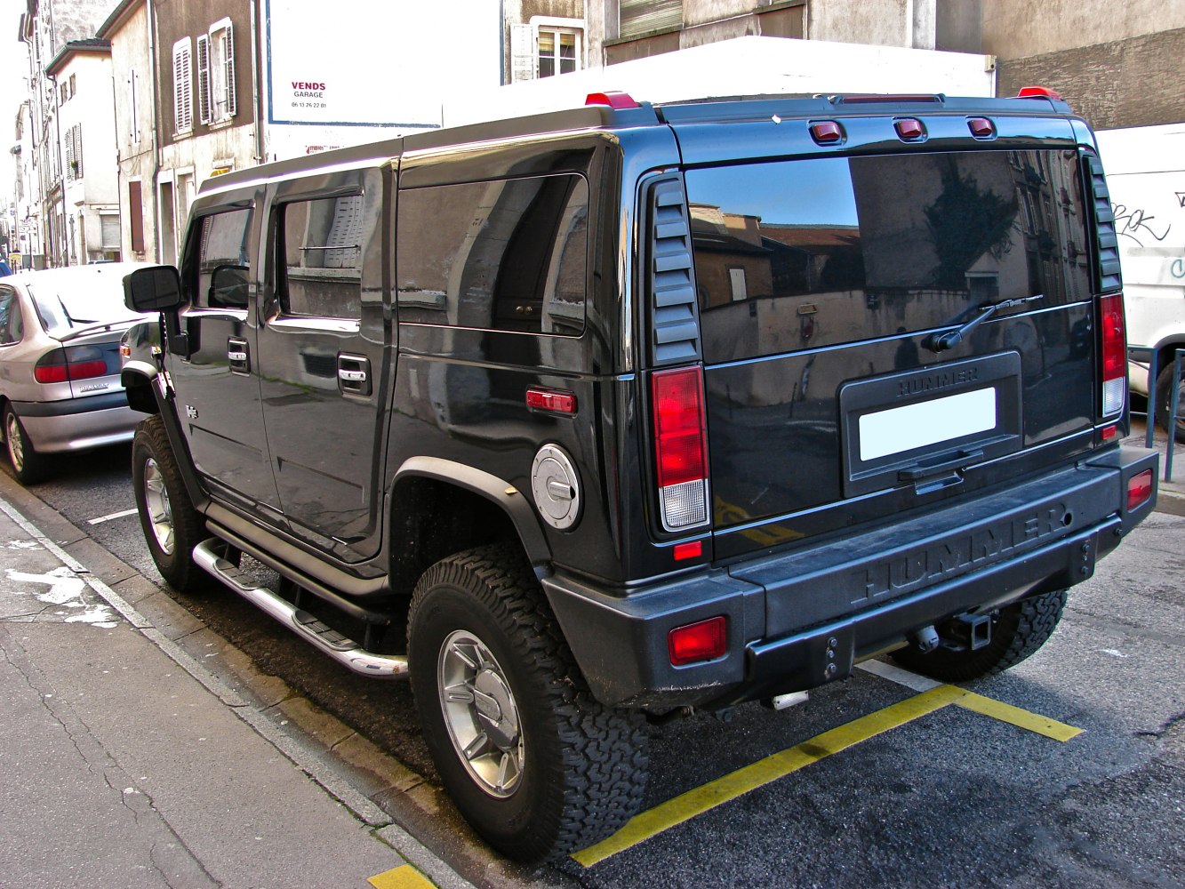 Rear view of an off-road SUV with rugged tires and chrome side steps