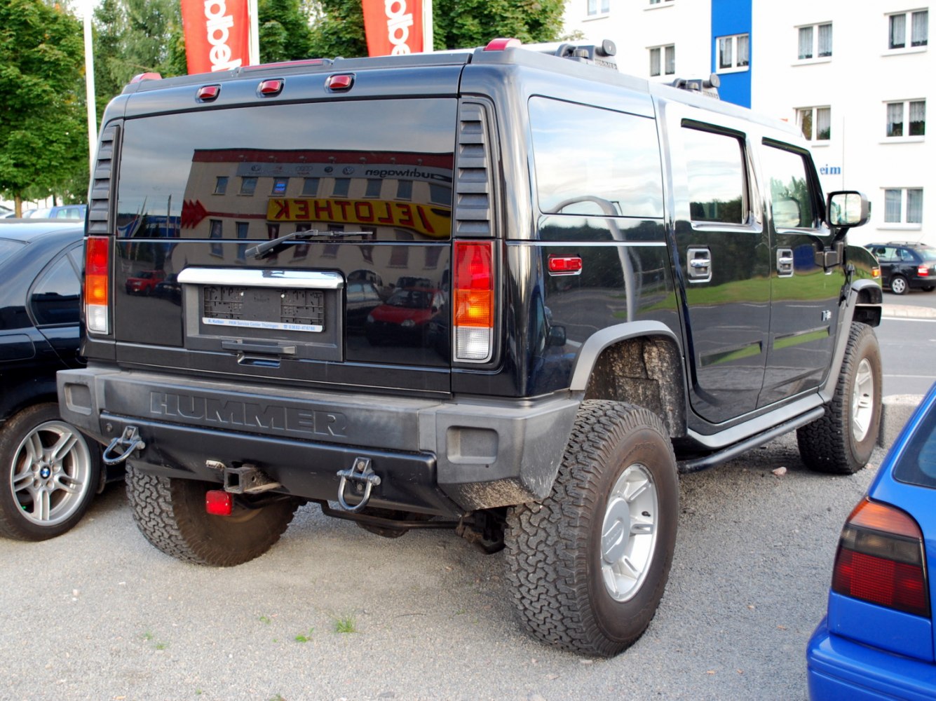 Rear view of a black SUV with large off-road tires and vertical taillights