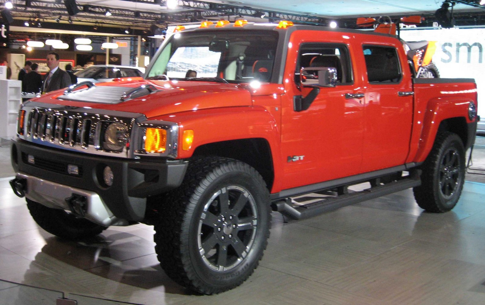 Orange pickup truck with off-road tires and chrome grille