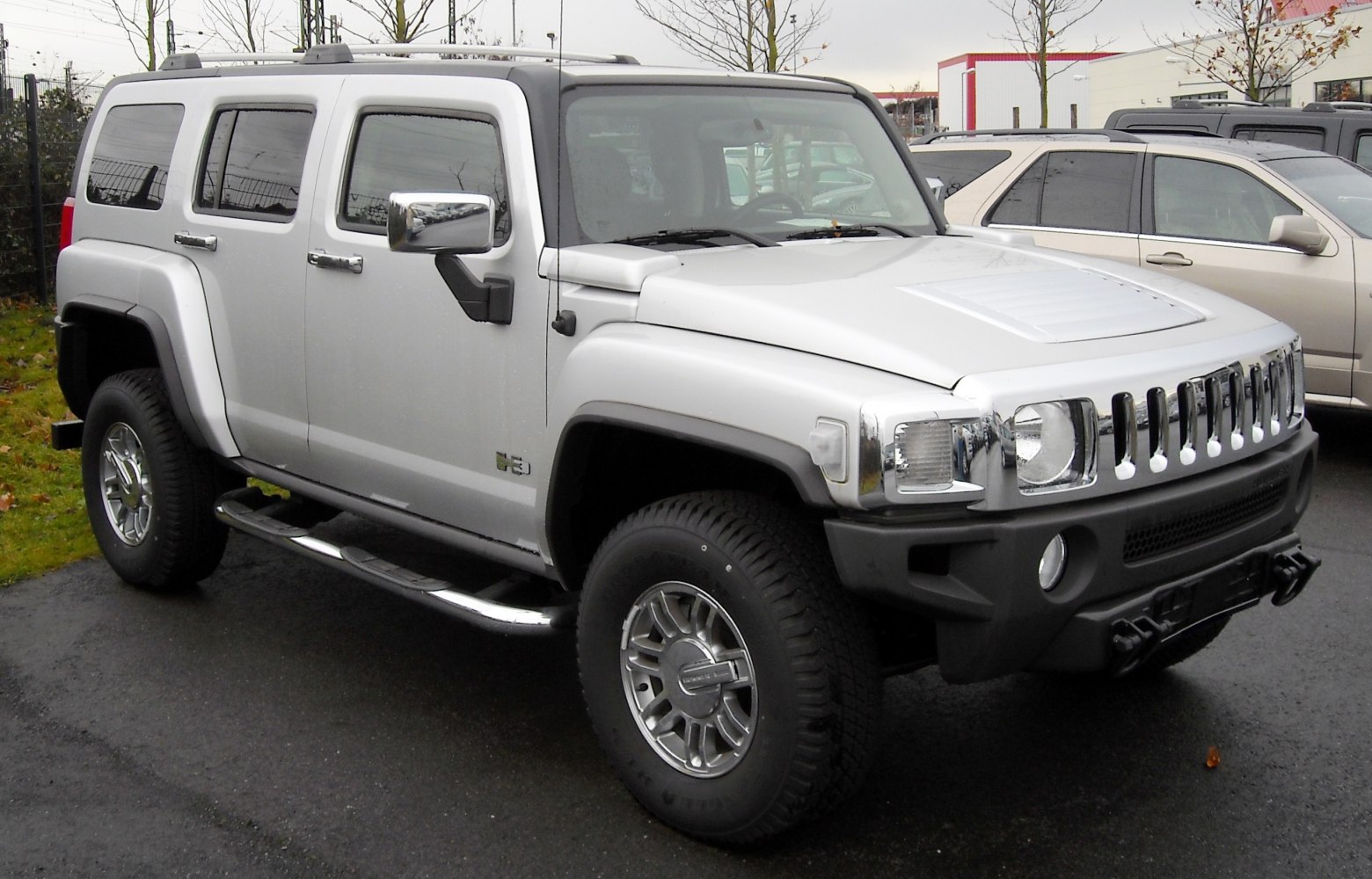 Aggressive front grille, vented hood, chrome side steps, off-road tires