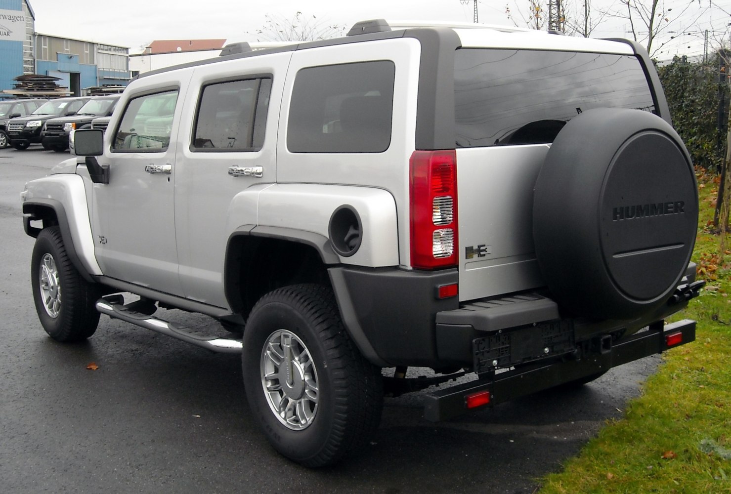Rear side view showcasing spare tire cover and off-road tires on an SUV