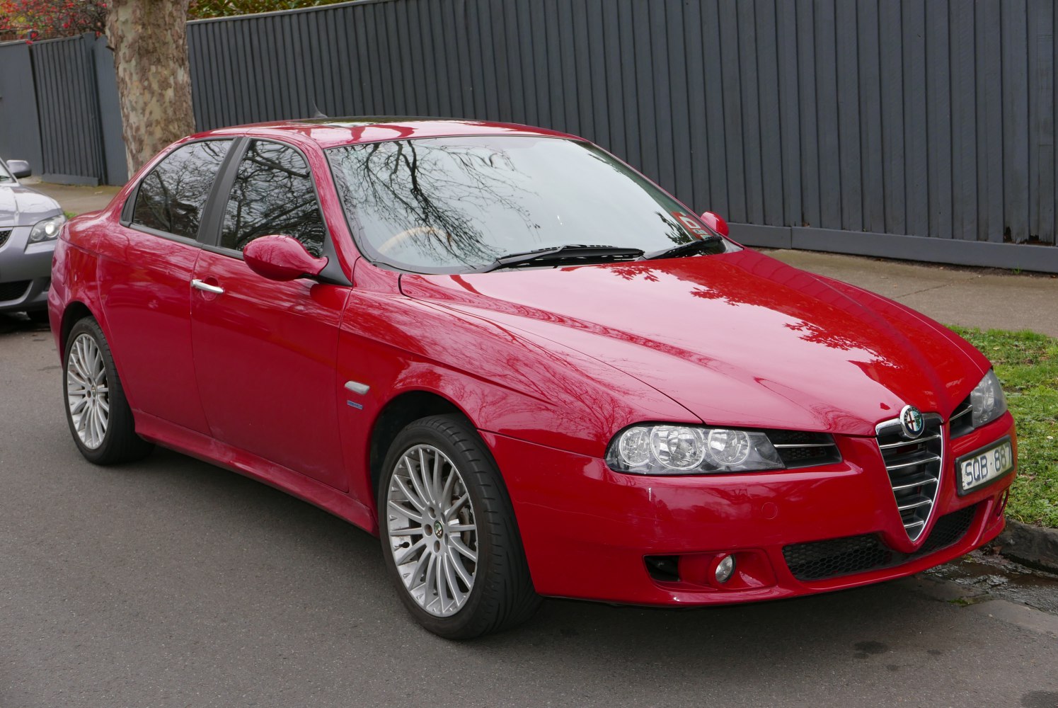 Red sedan with distinctive grille and dual round headlights