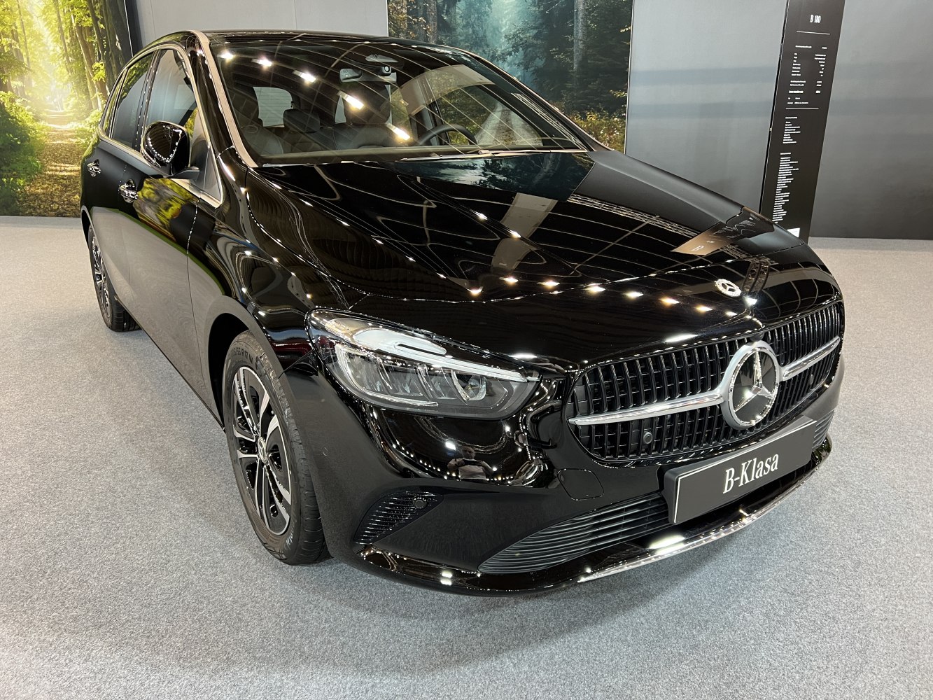 Front view of glossy black vehicle with distinctive grille and LED headlights