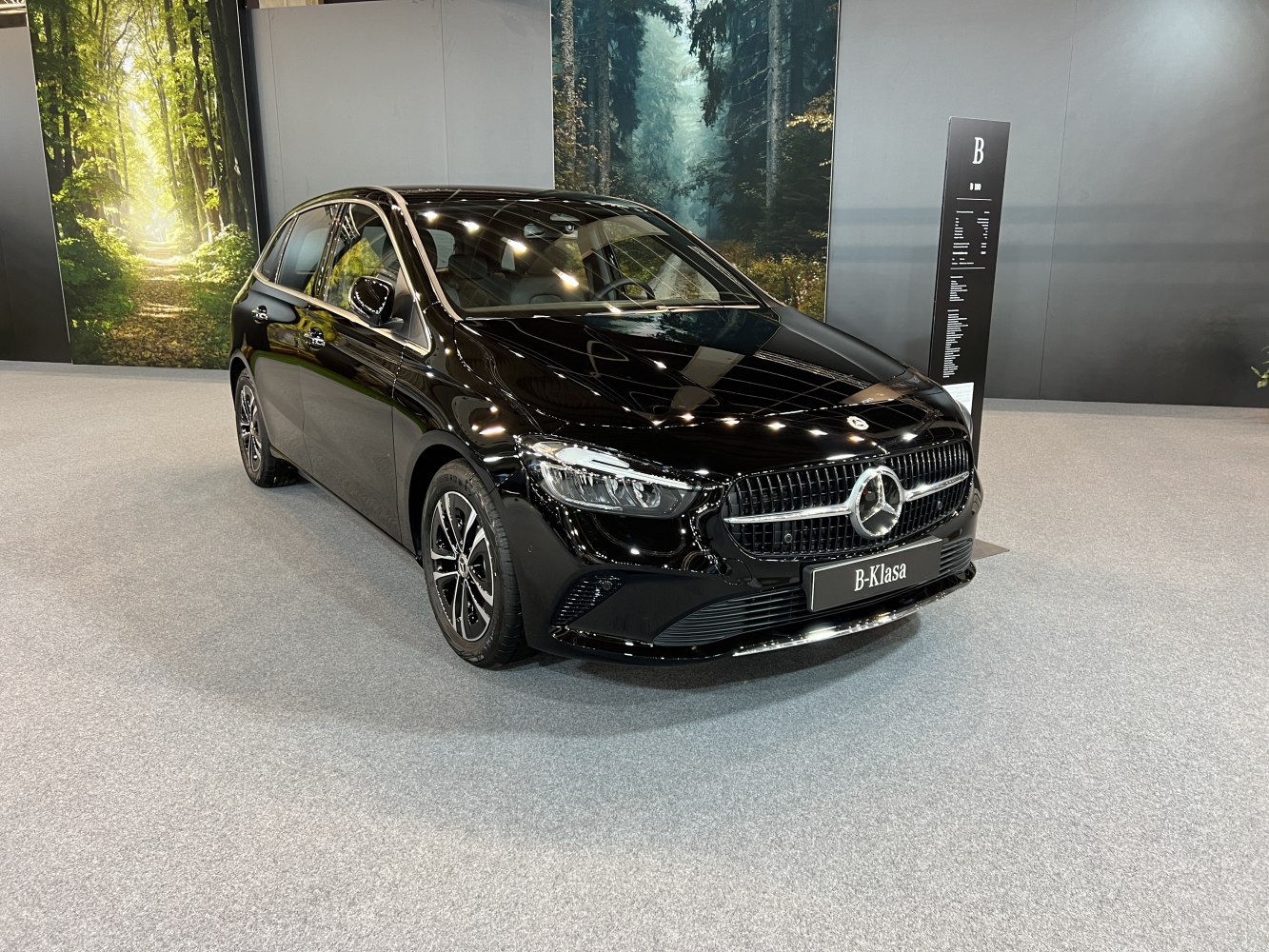 Glossy black compact hatchback with distinctive front grille and LED headlights