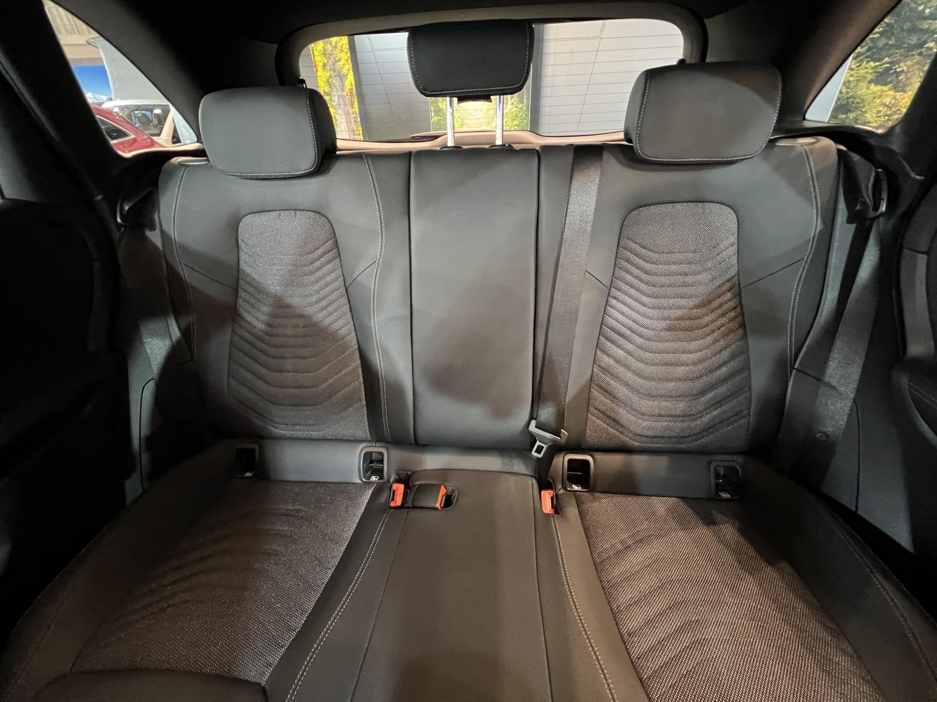 Rear seats with headrests, seat belts, and textured upholstery