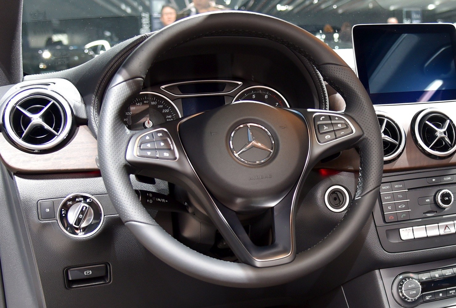 Steering wheel, dashboard controls, and air vents in a modern car interior