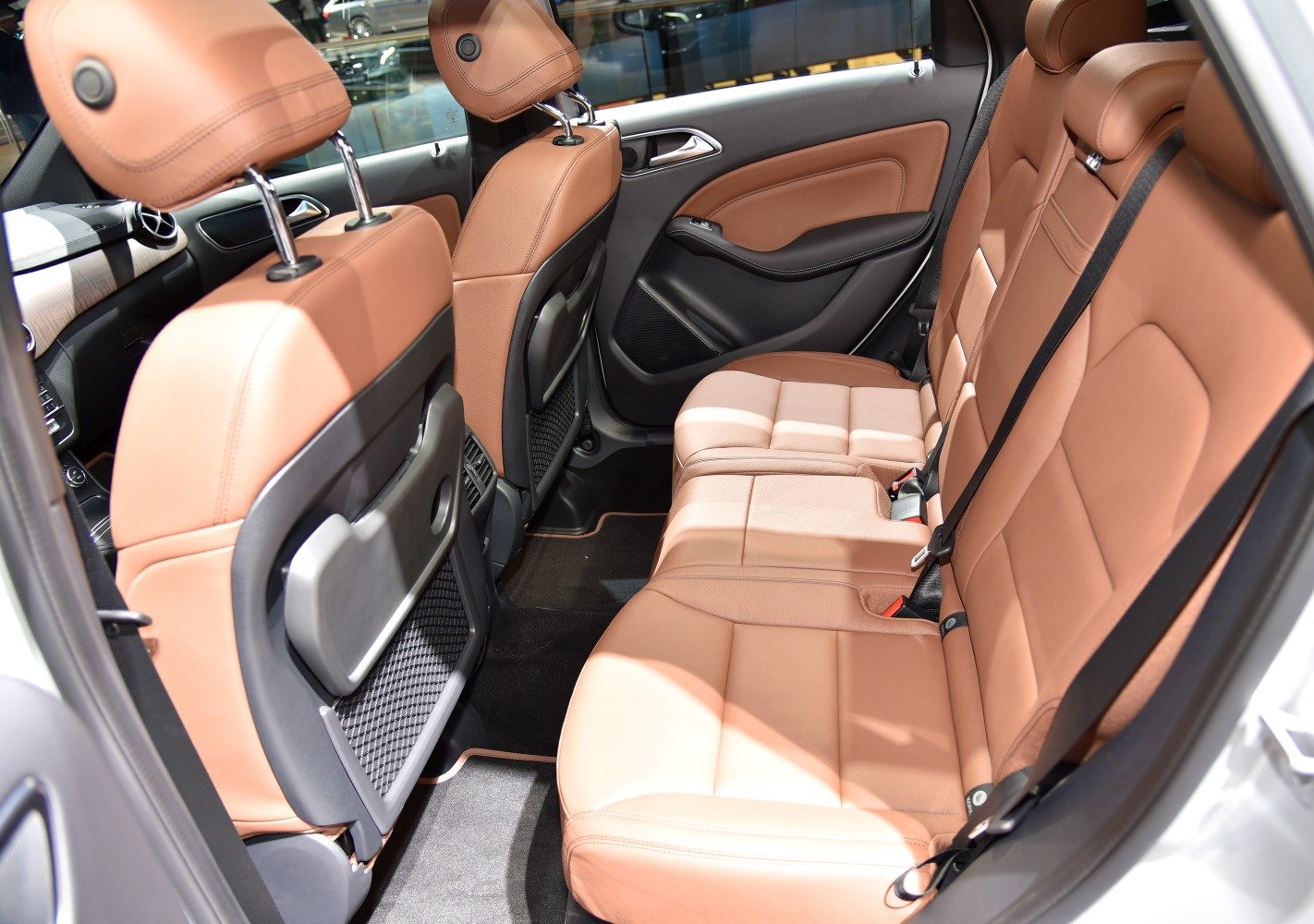 Tan leather rear seats with foldable tray tables and spacious legroom