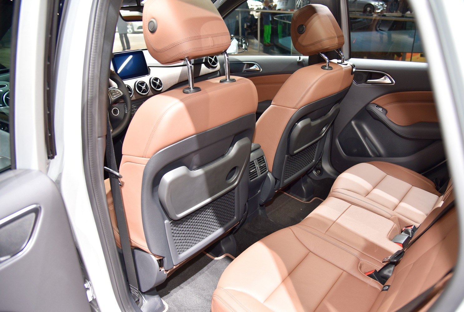 Rear interior with tan leather seats, foldable trays, and air vents