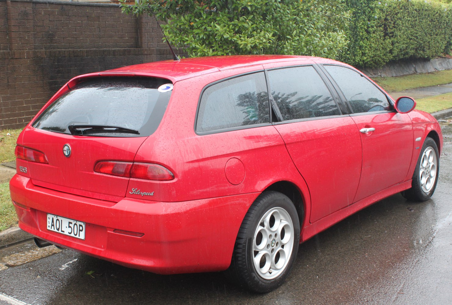 Red hatchback rear side with distinctive taillights and alloy wheels