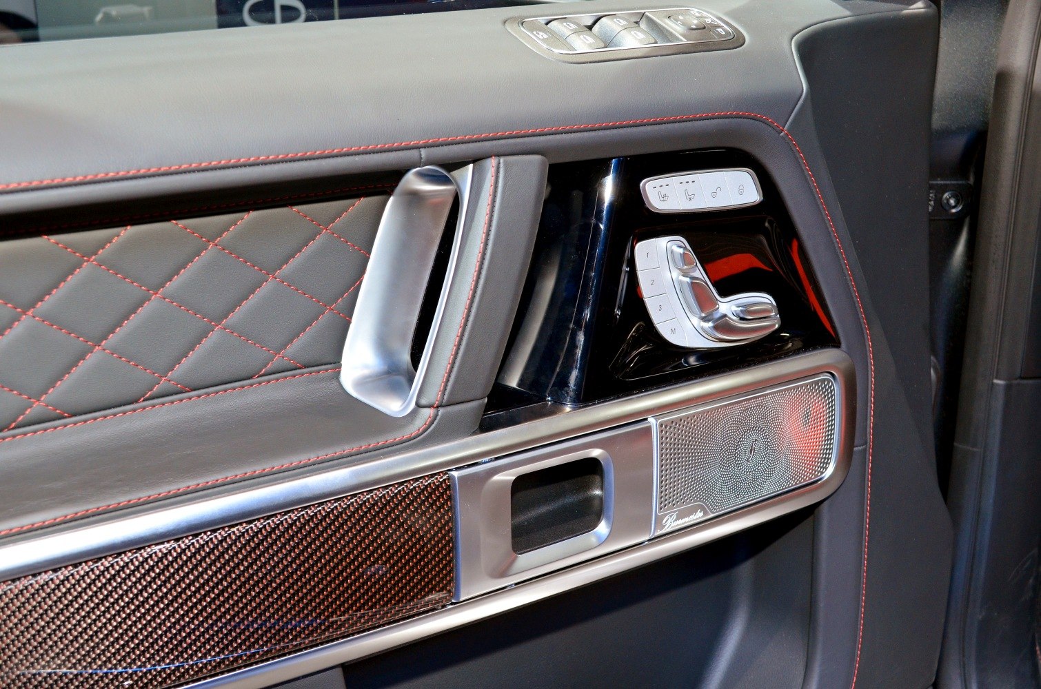 Quilted leather door panel with metallic handle and seat control buttons