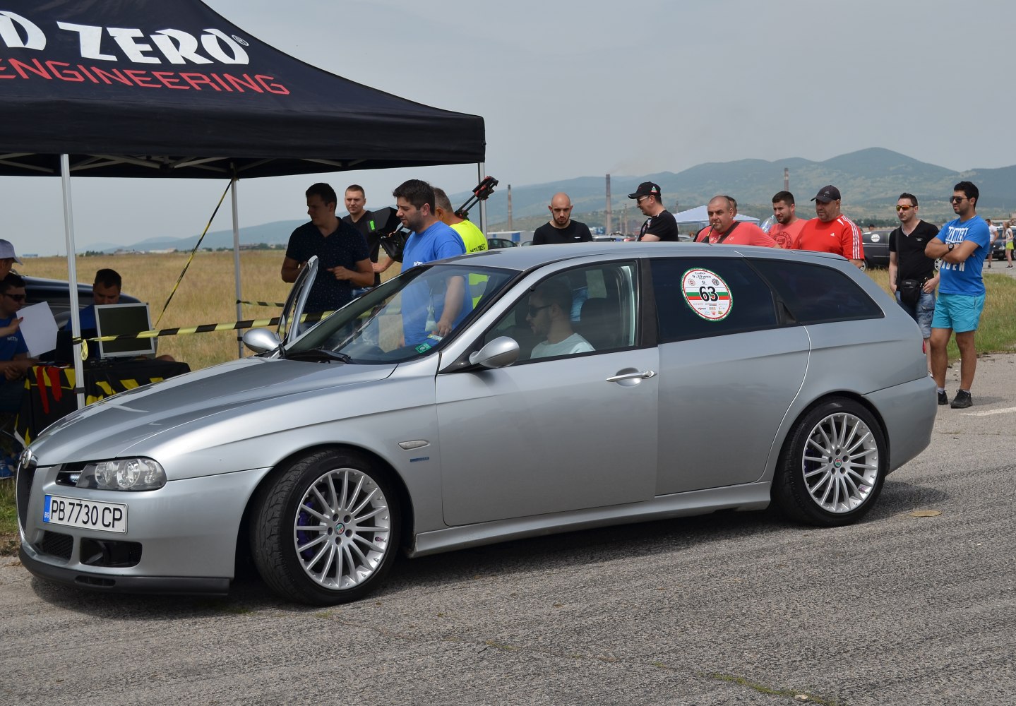 Silver sport wagon with multi-spoke alloy wheels and open door.