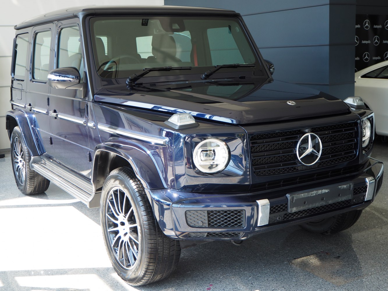 Front and side view of luxury SUV with round headlights and robust grille