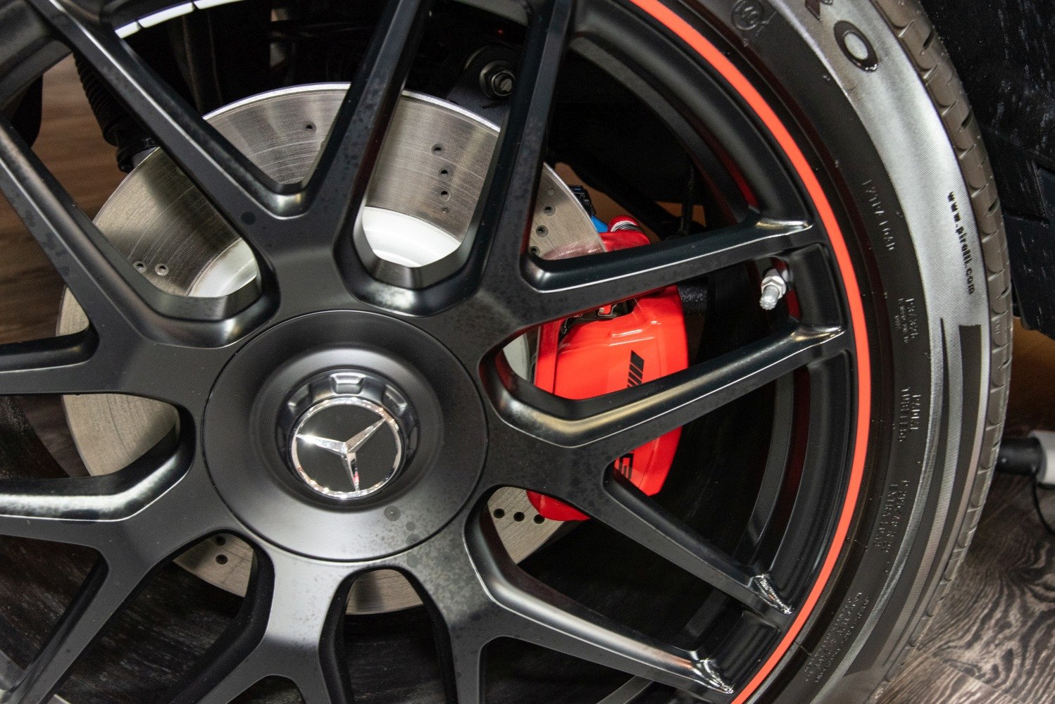 Black AMG wheel with drilled disc brake and red performance brake caliper