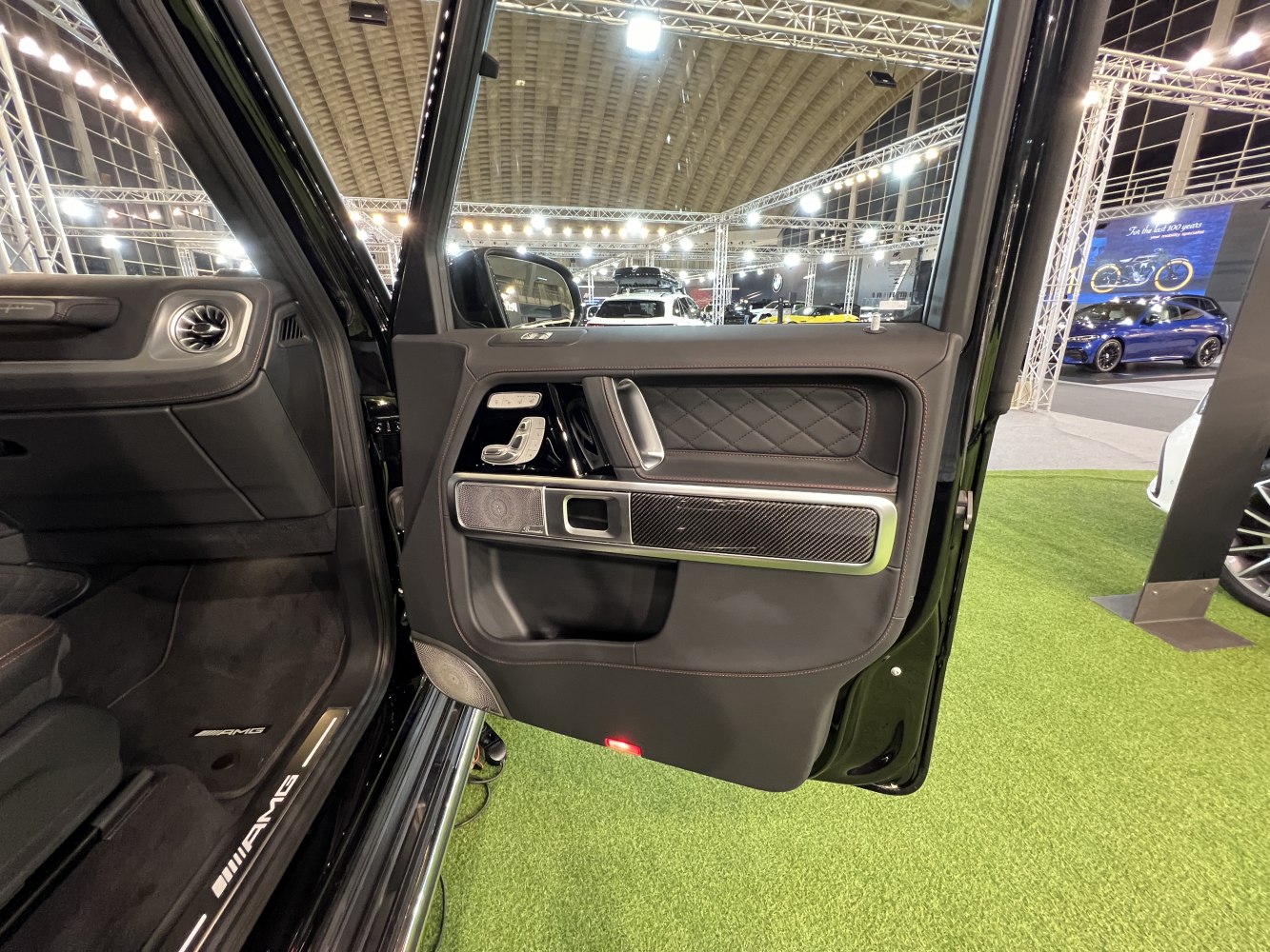 Luxury car door interior with carbon fiber trim and quilted leather