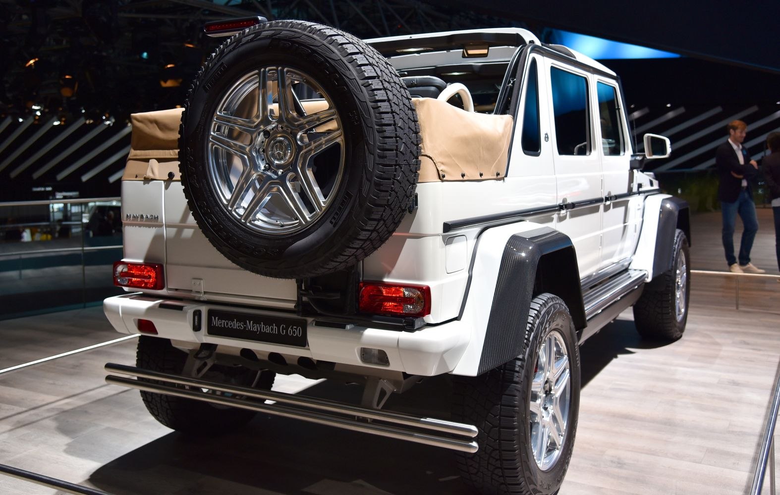 Rear view with spare wheel, beige canopy, and chrome exhaust