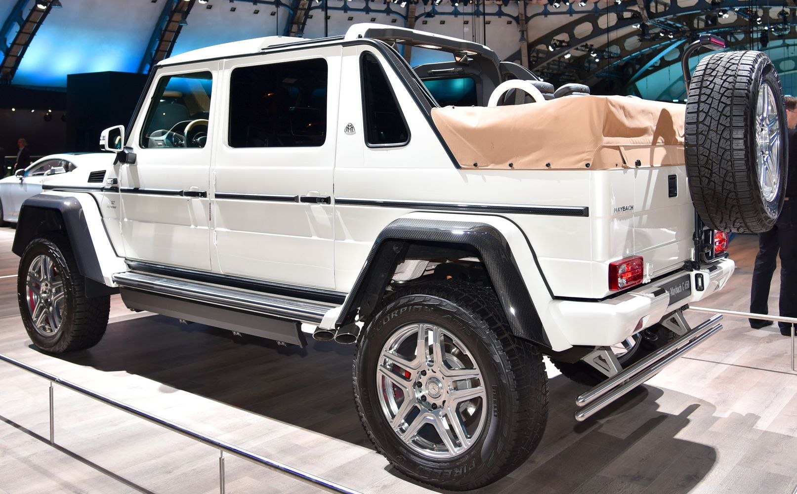 White luxury SUV with convertible soft top and chrome multi-spoke wheels.