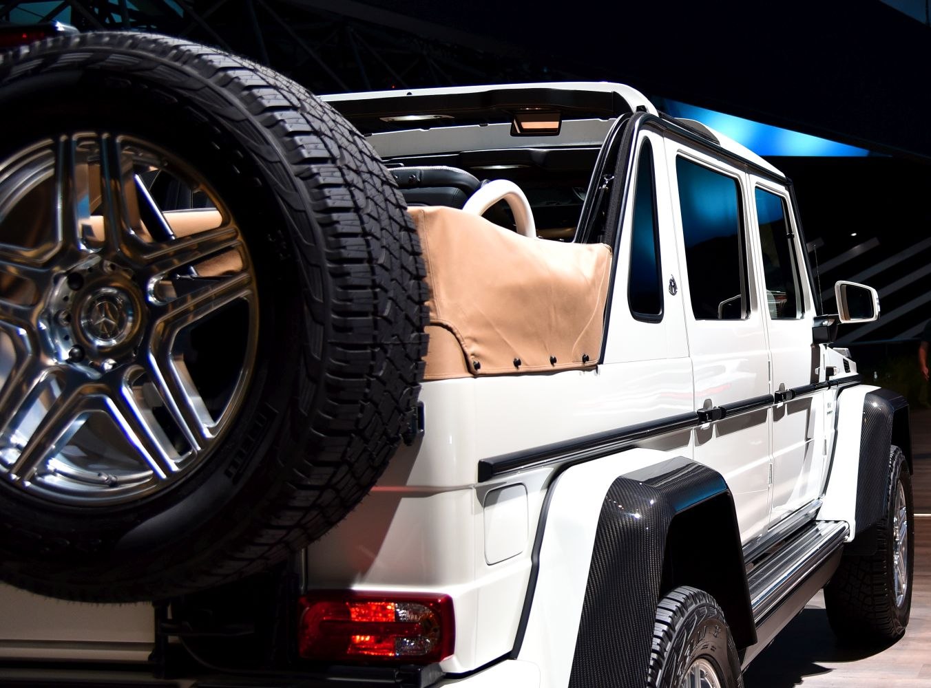 Spare tire on rear door and beige soft top cover on luxury SUV rear