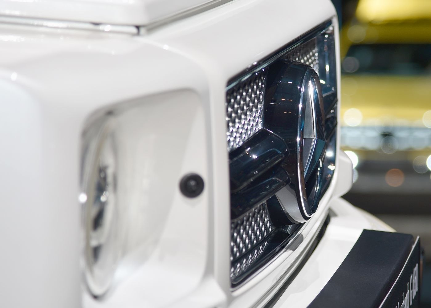 Close-up of luxury SUV grille and rounded headlight
