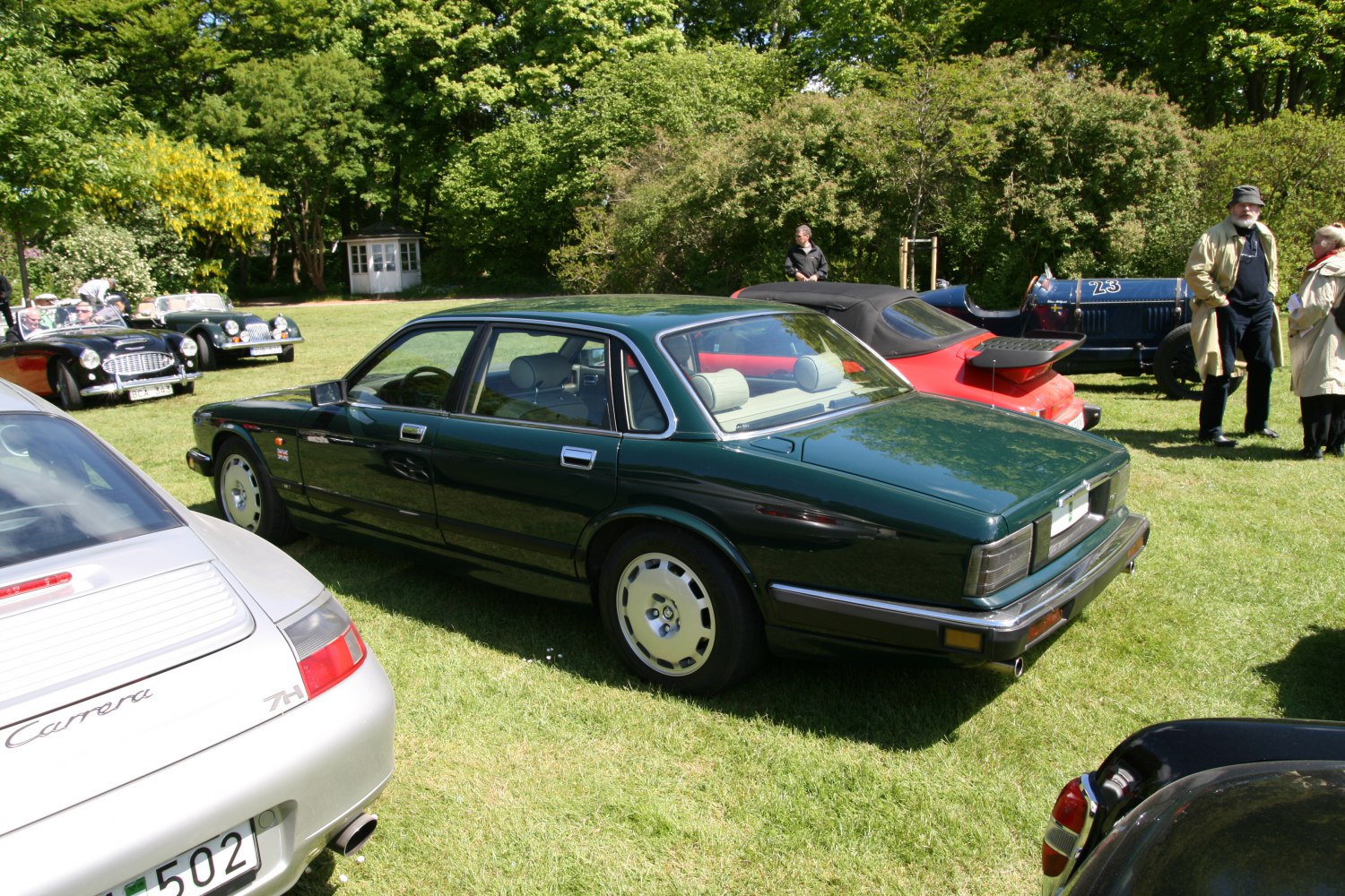 Classic sedan rear-side view with unique wheels and vintage design.