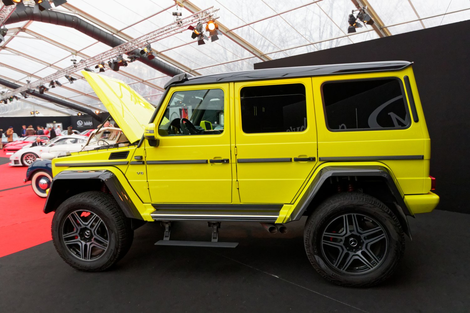 Yellow off-road SUV side view with open hood and black rims
