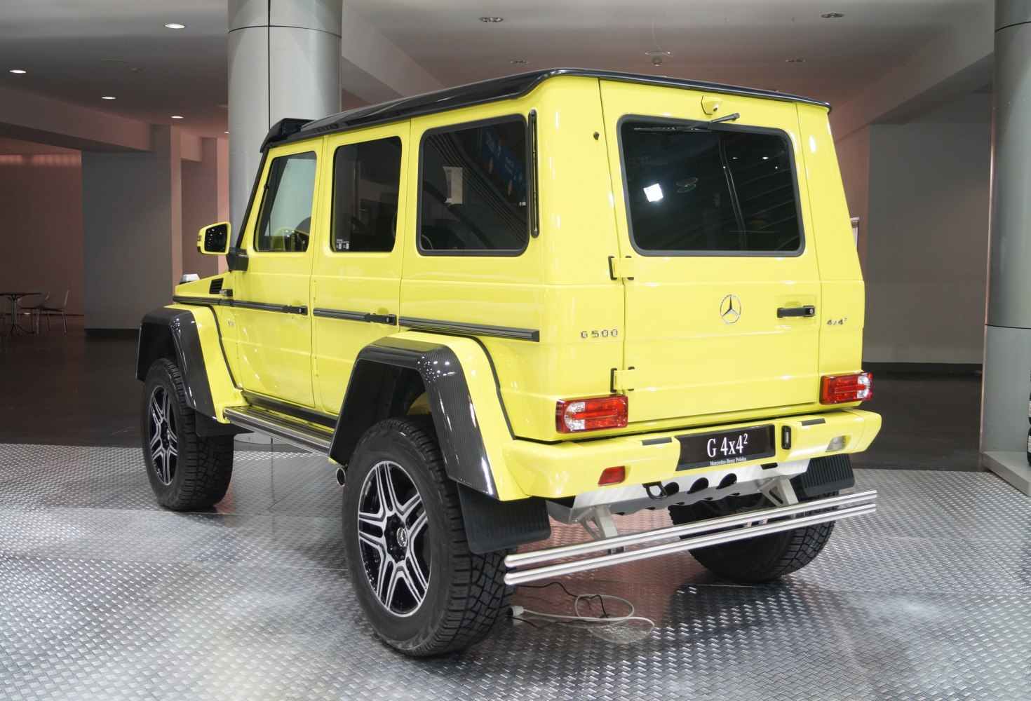 Yellow SUV with black roof and wide wheel arches rear side view