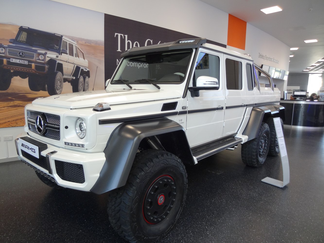 White 6x6 off-road SUV with six wheels and rugged fender flares