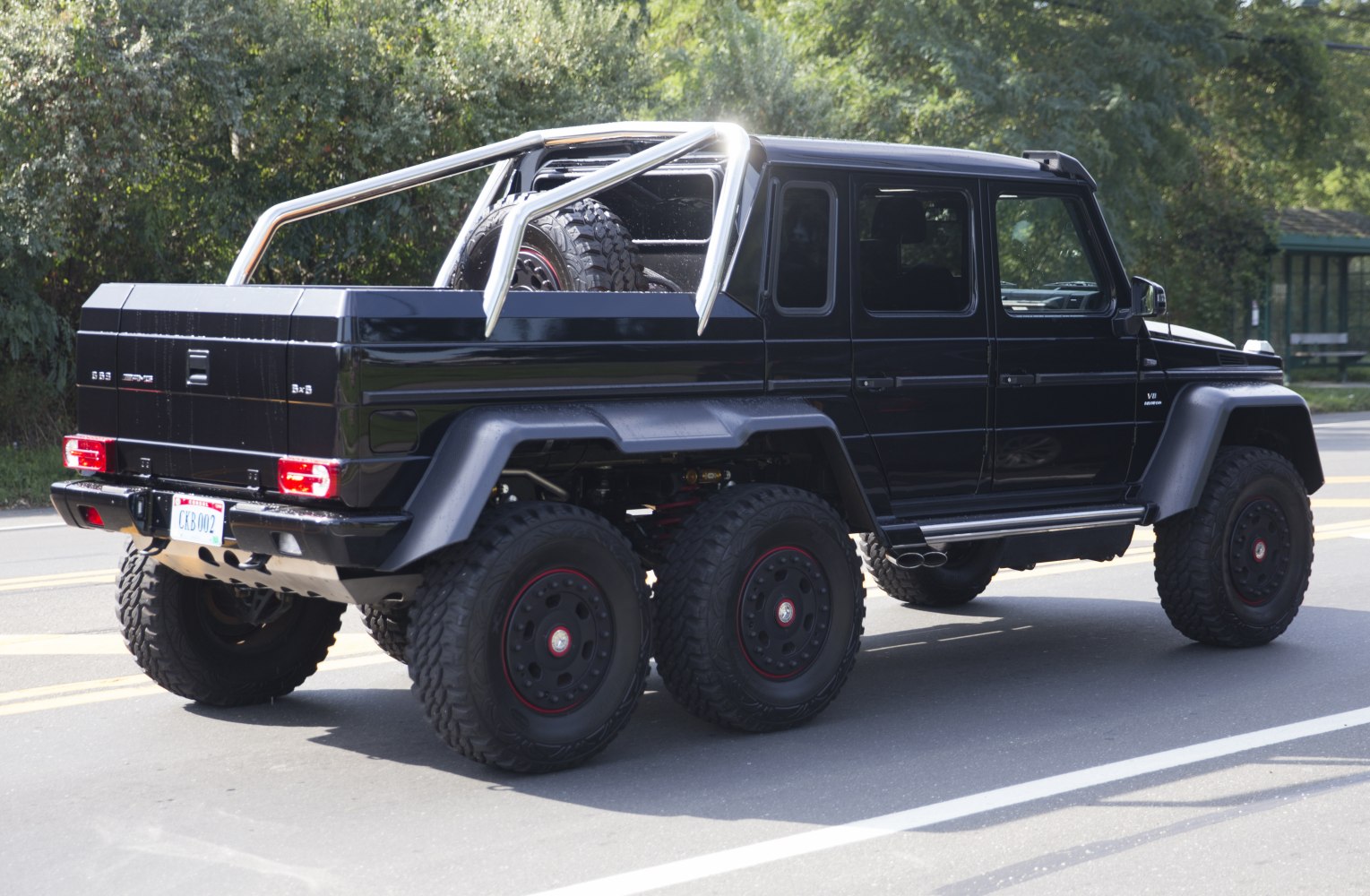 Black six-wheel Mercedes-style off-road SUV with roll cage