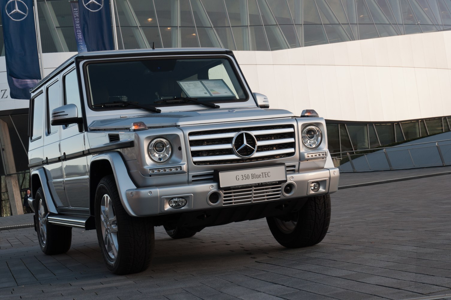 Front view of silver large SUV with round headlights and wide grille