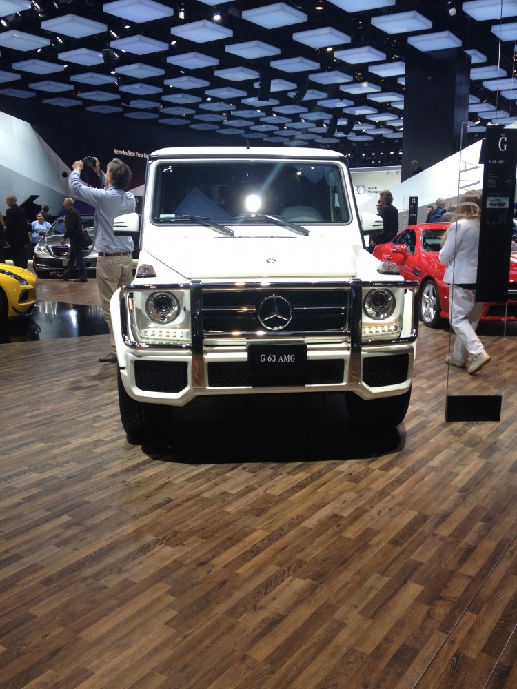 Front view of white luxury off-road SUV with AMG grille and square headlights