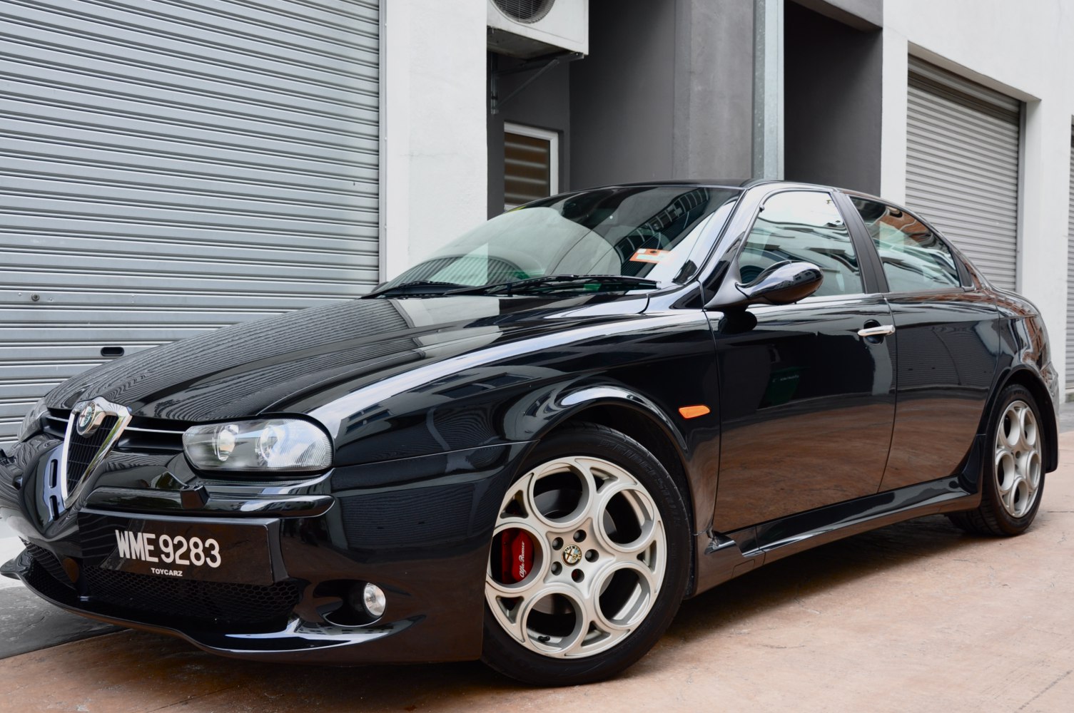 Front-side view of a sporty black sedan with alloy wheels