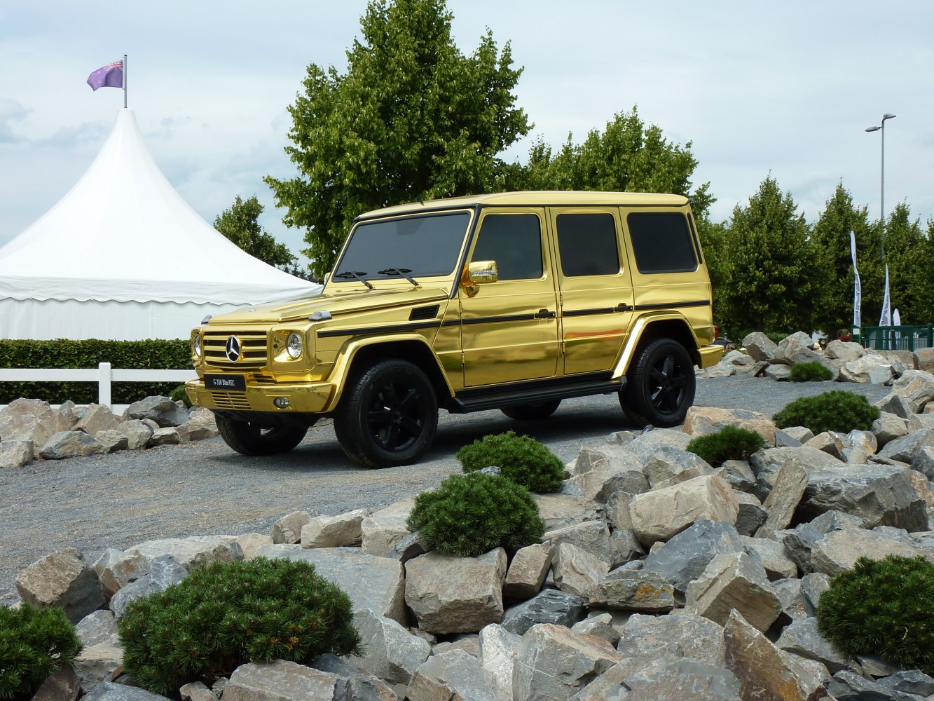 Boxy gold luxury SUV with black rims and off-road stance