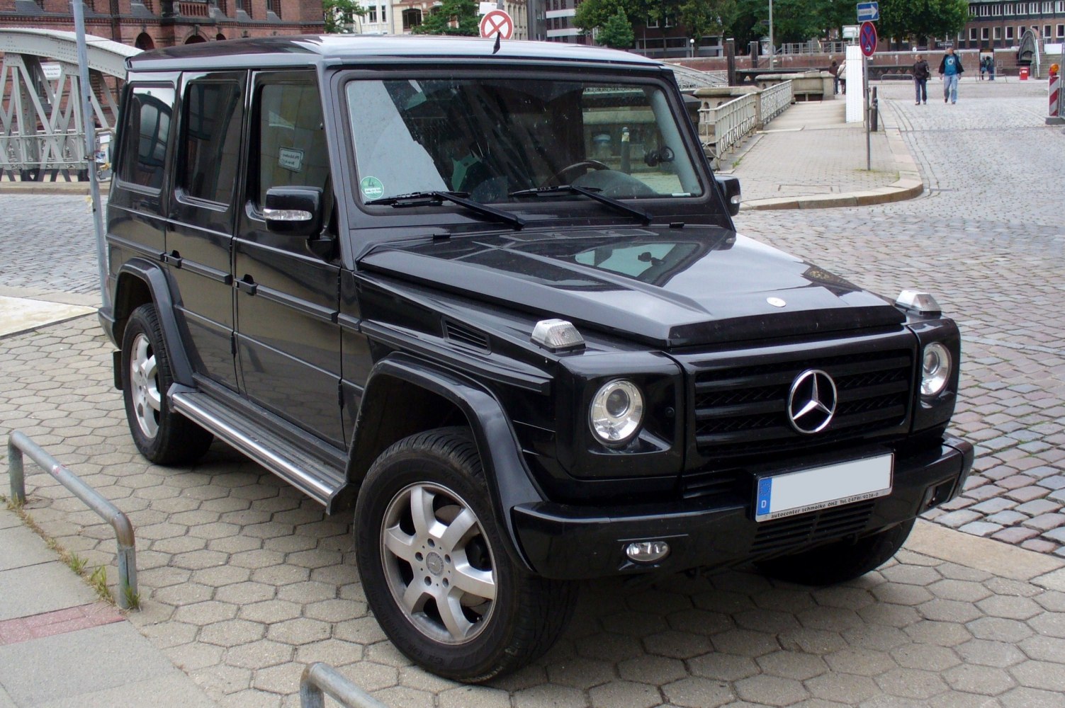 Boxy SUV front-side view with round headlights and side steps
