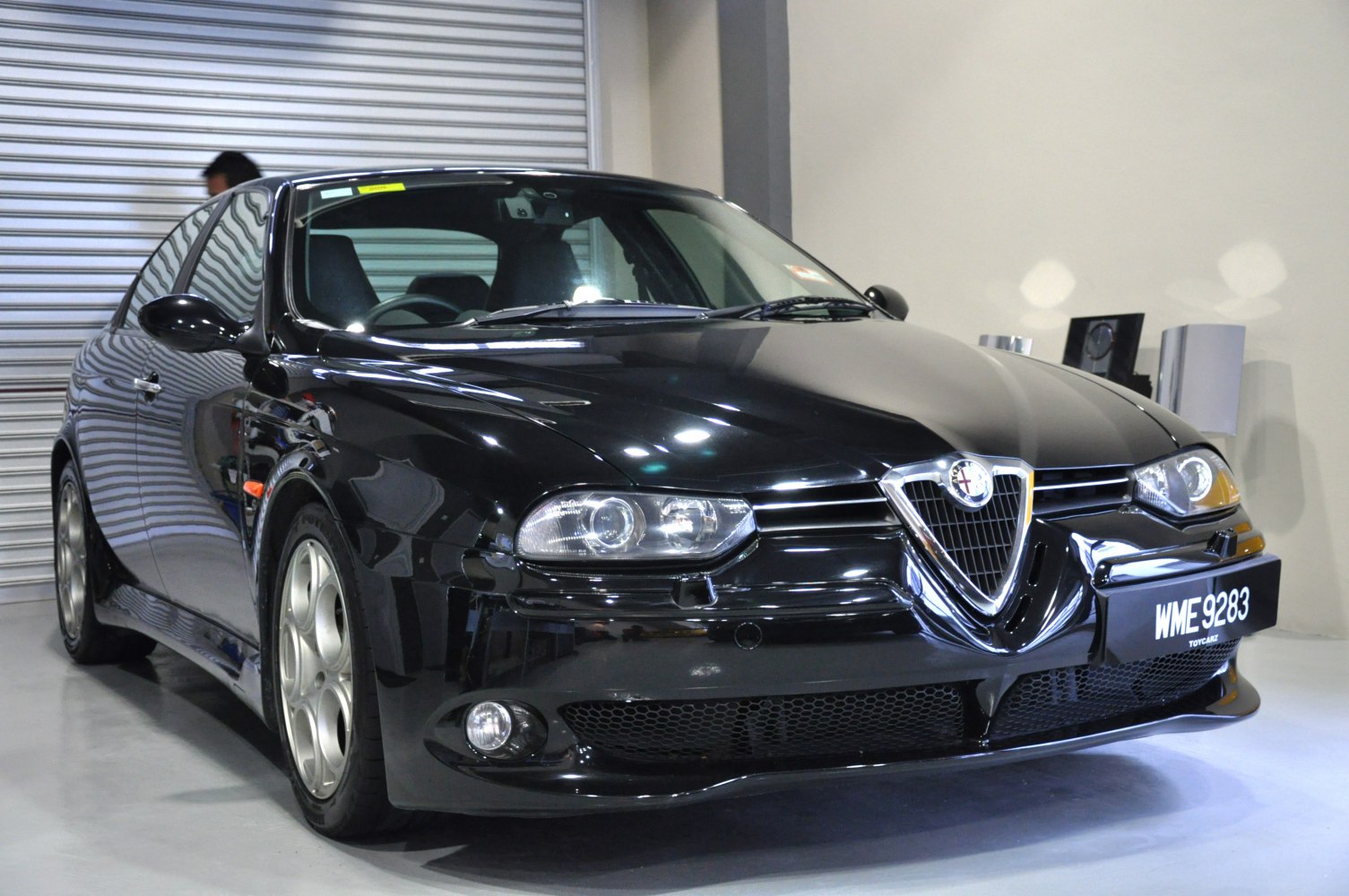 Glossy black front with Alfa Romeo's iconic shield grille and sleek headlights.