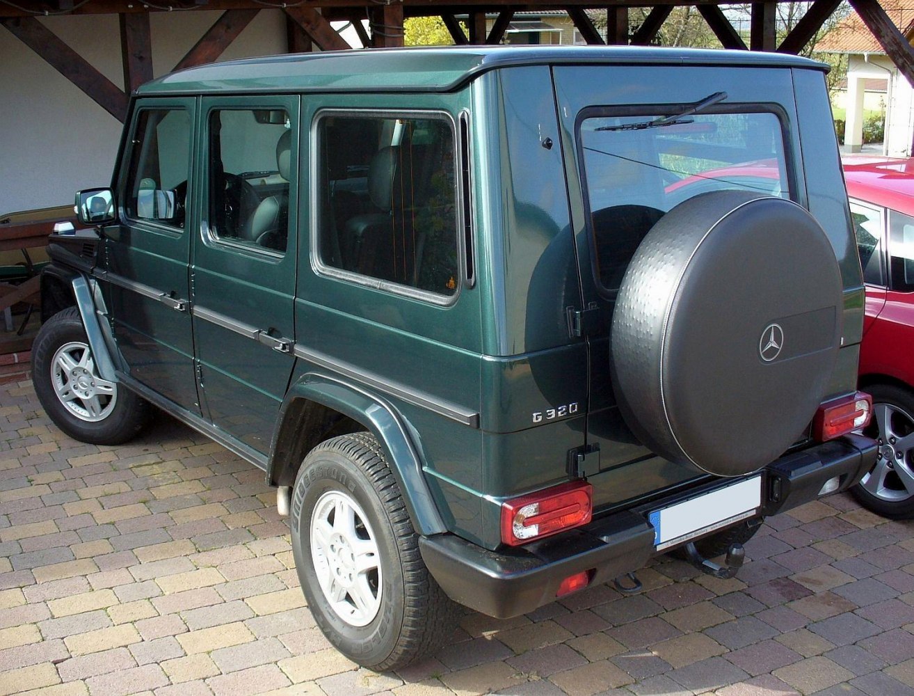 Rear and side view of an SUV with boxy shape and spare tire cover