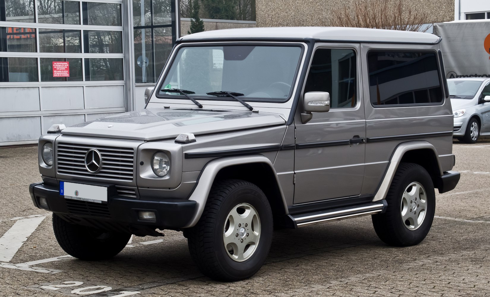 Front side view of a boxy classic SUV with alloy wheels and side steps