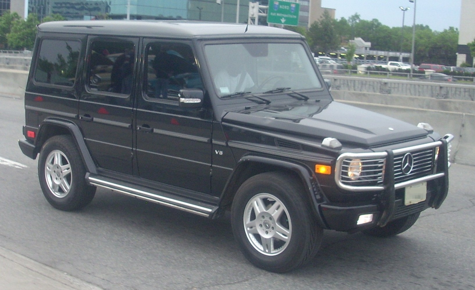 SUV with long body, frontal grille guard, and V8 badge