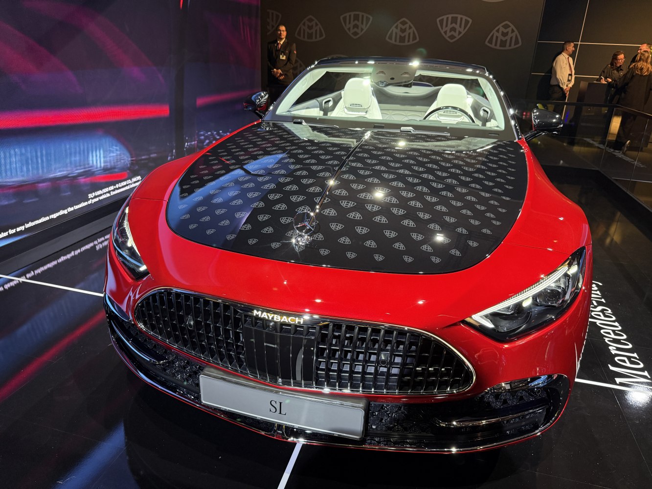 Front view of red luxury coupe with patterned hood and white leather interior