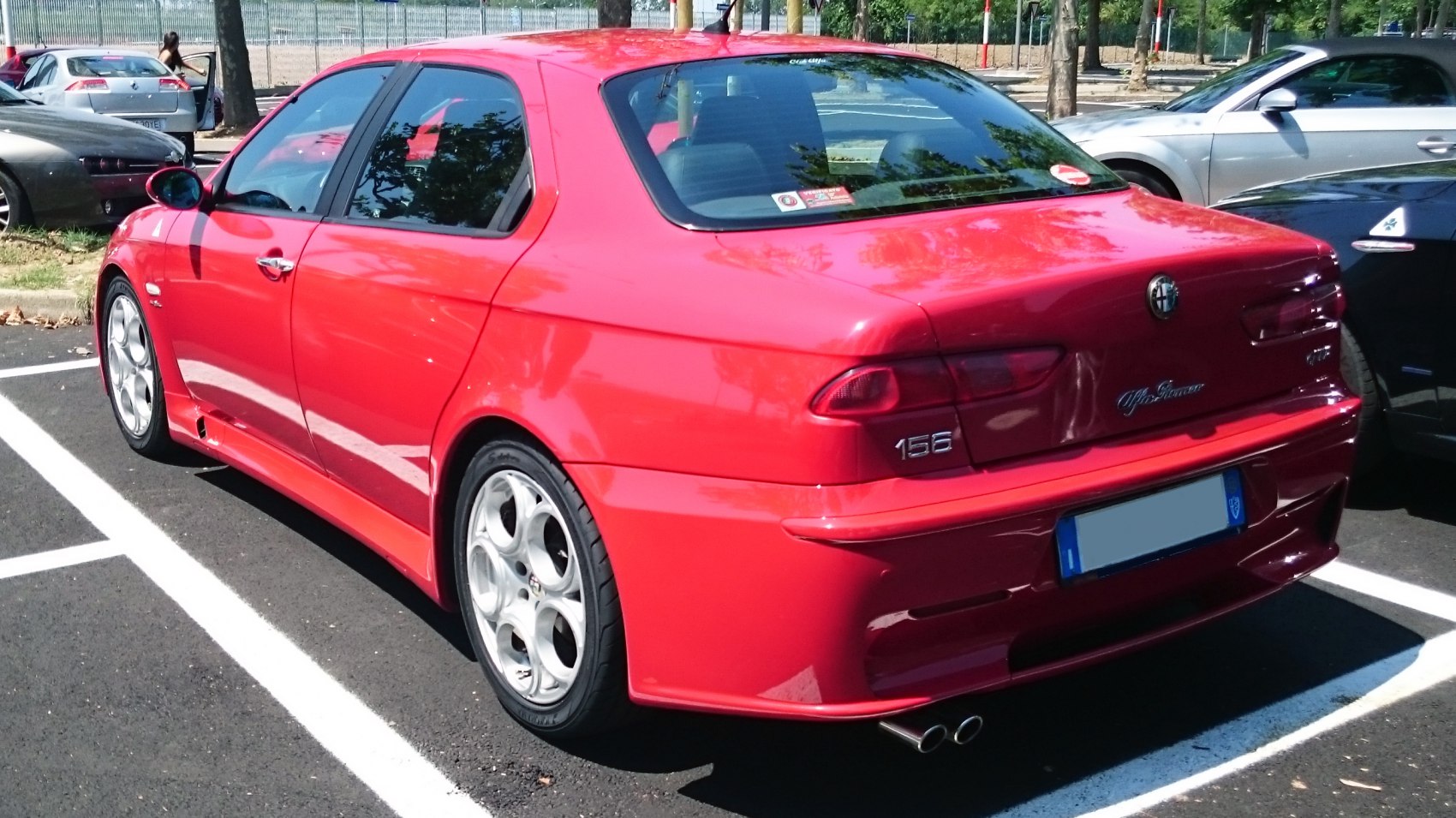 Red sedan rear side with dual exhaust and unique rims