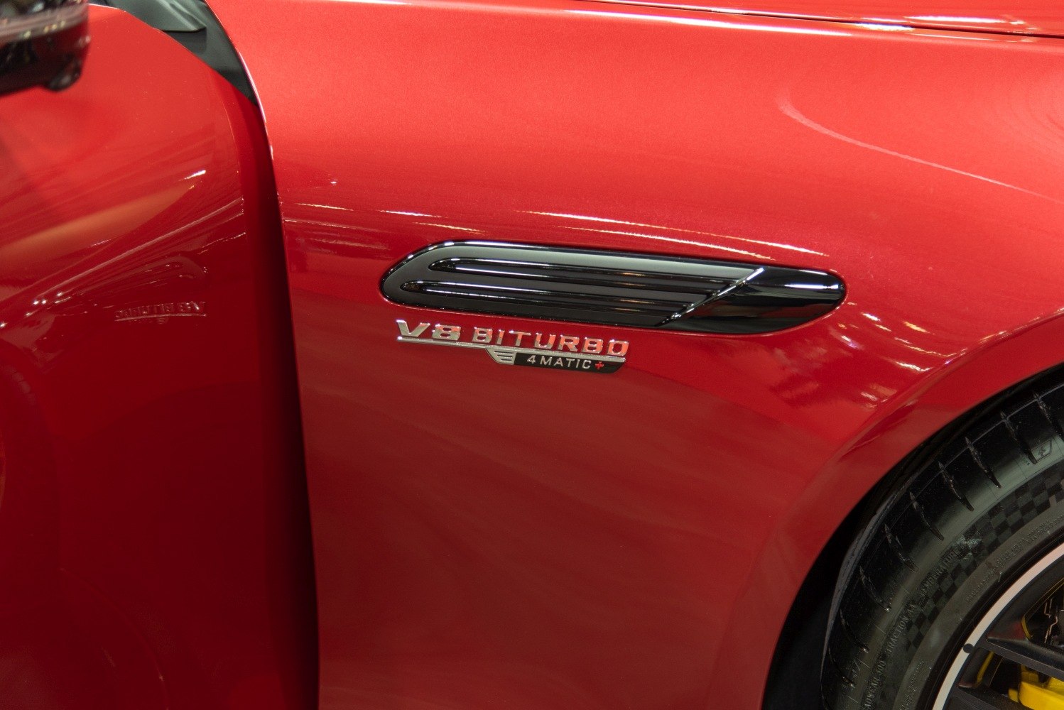 V8 Biturbo 4MATIC+ badge and side vent on red car body