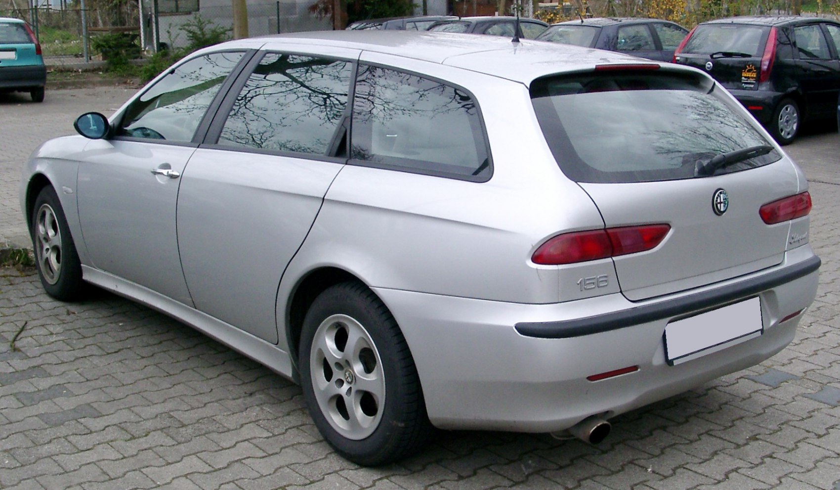Rear side view of silver station wagon with distinct taillights and sporty rear design.