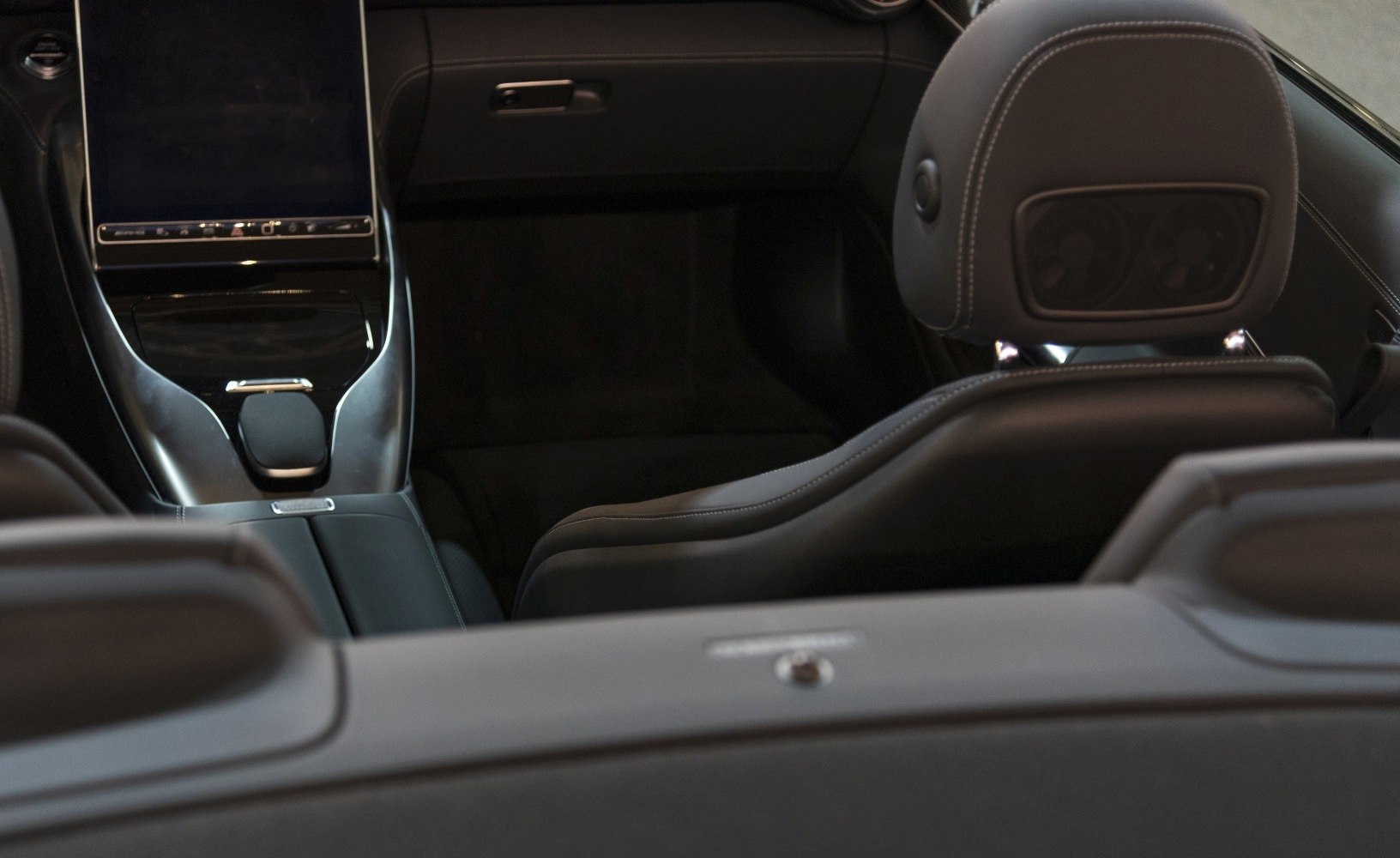 Luxury car interior with touchscreen, leather seats, and headrest speakers
