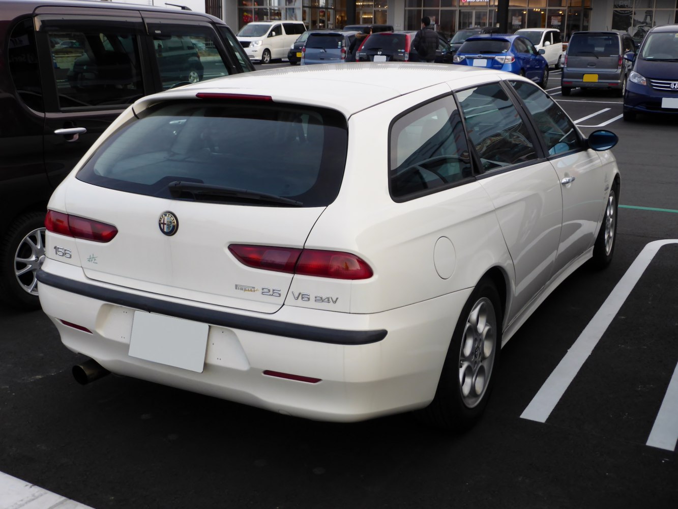 Rear view of a white hatchback with distinctive taillights and sporty rear design