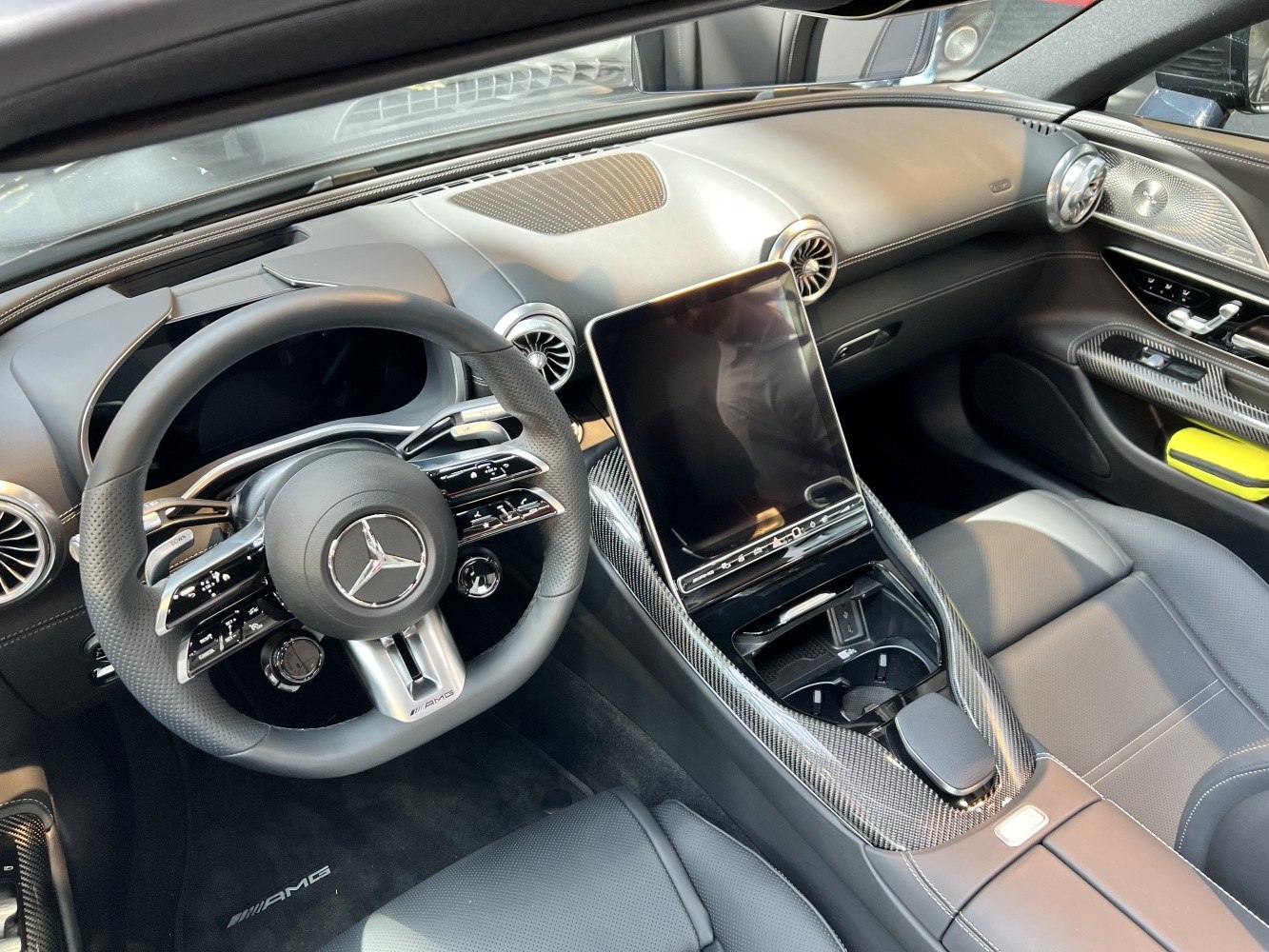 Luxury cockpit with AMG steering wheel and central touchscreen display.