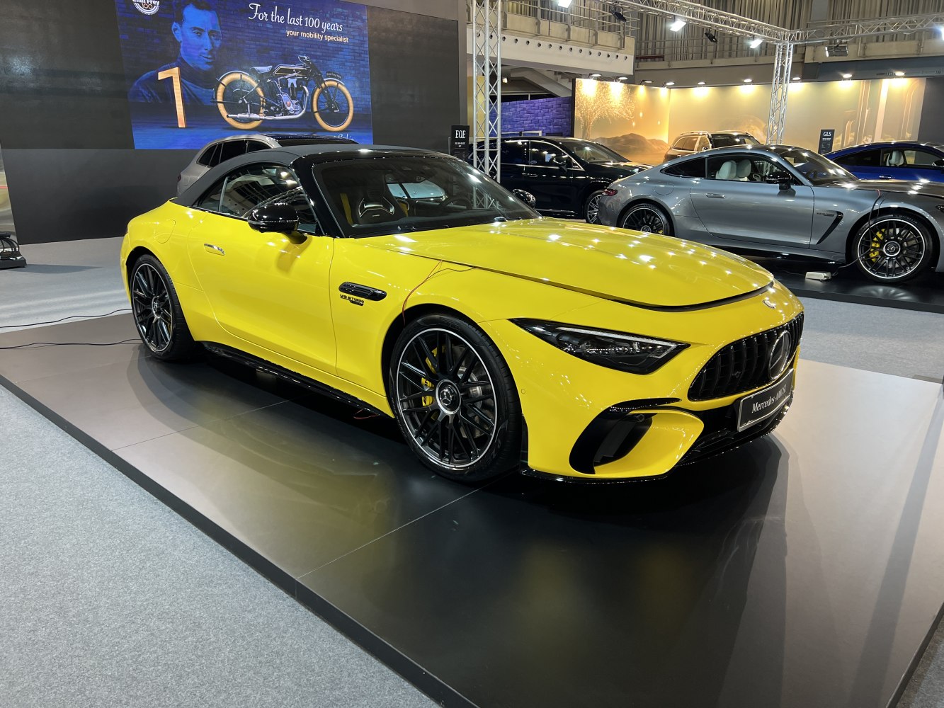Yellow convertible with V8 biturbo badge and black front grille on multi-spoke wheels