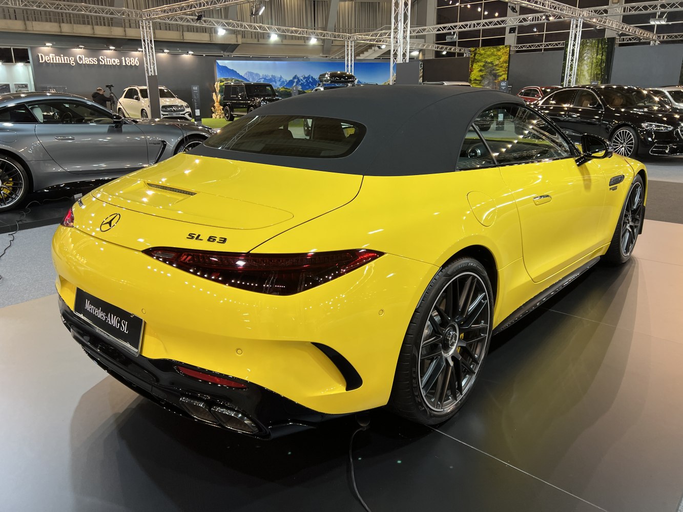 Rear view of yellow convertible with black soft top and sporty taillights
