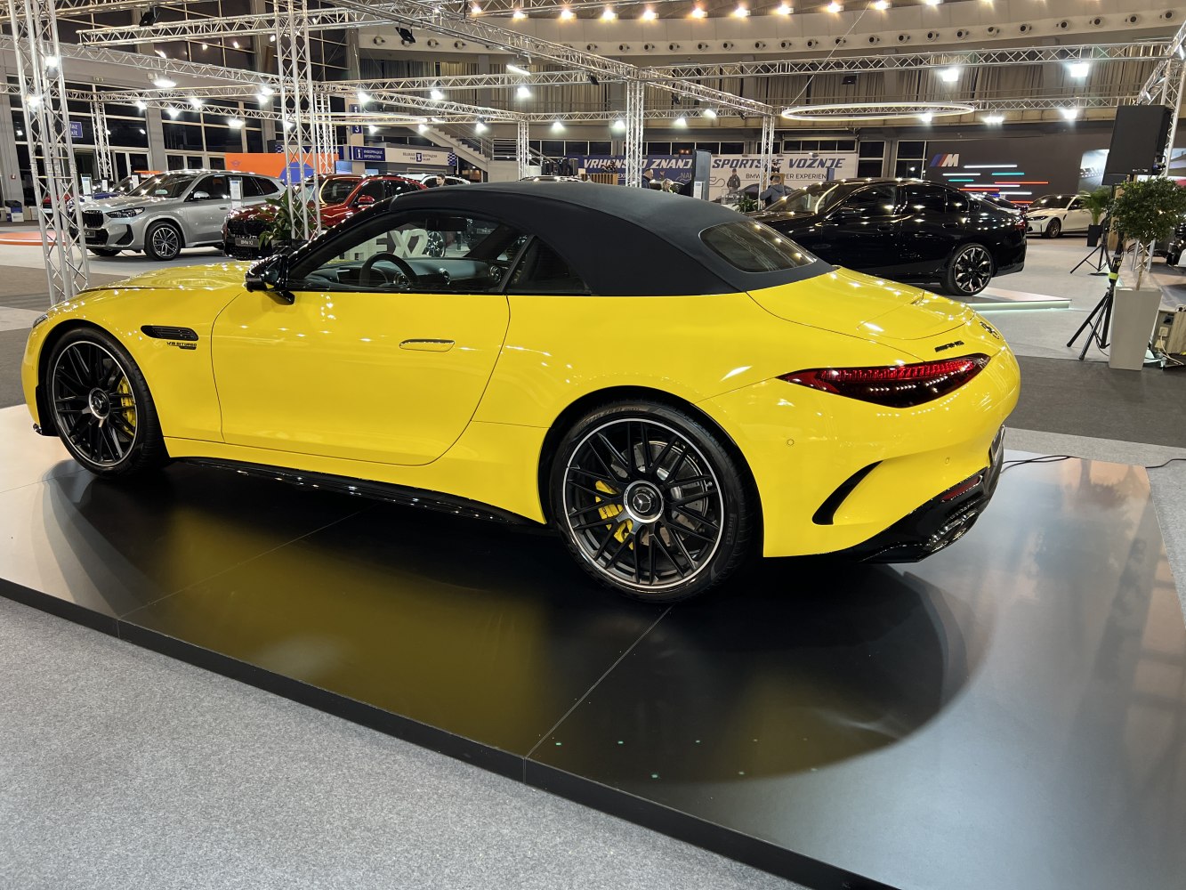 Yellow convertible with black soft-top and black multi-spoke alloy wheels