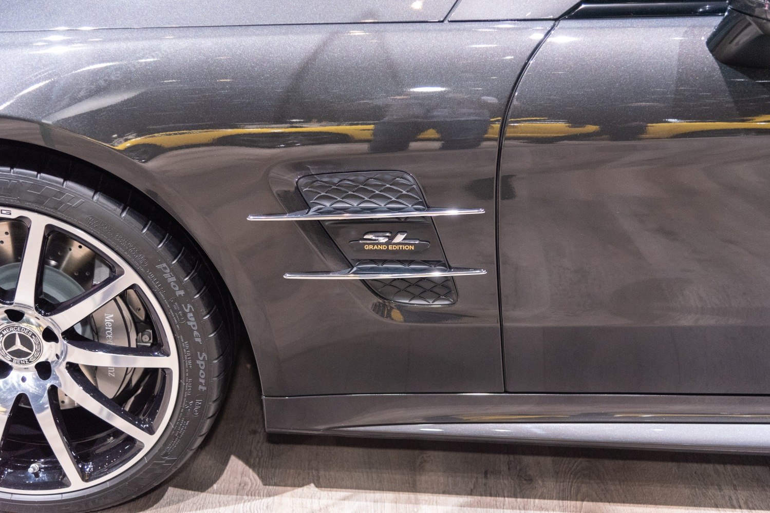 Close-up of side vent with Grand Edition badge and front wheel.