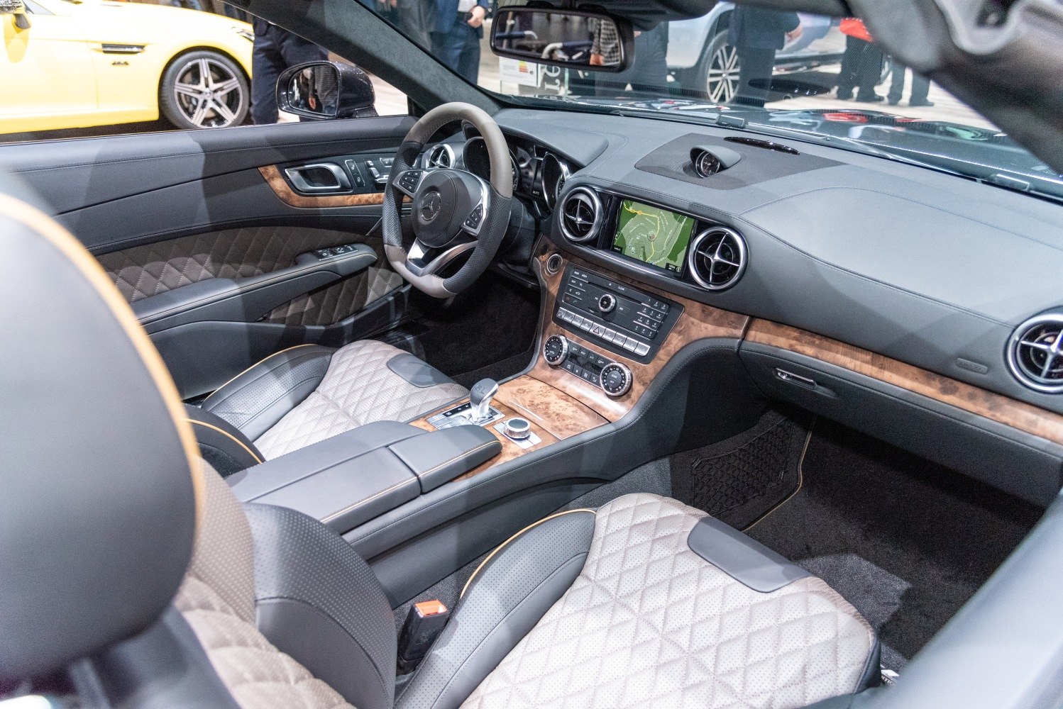Diamond-stitched leather seats and wood trim dashboard with infotainment system